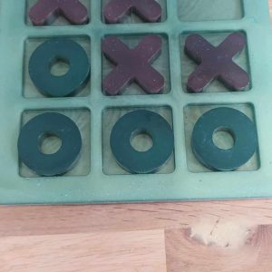 R/jeu de morpion rond vert et noir, croix rose transparent et noir, plateau vert