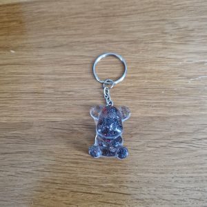 R/porte clés petit ourson assis feuilles rouges paillettes grises